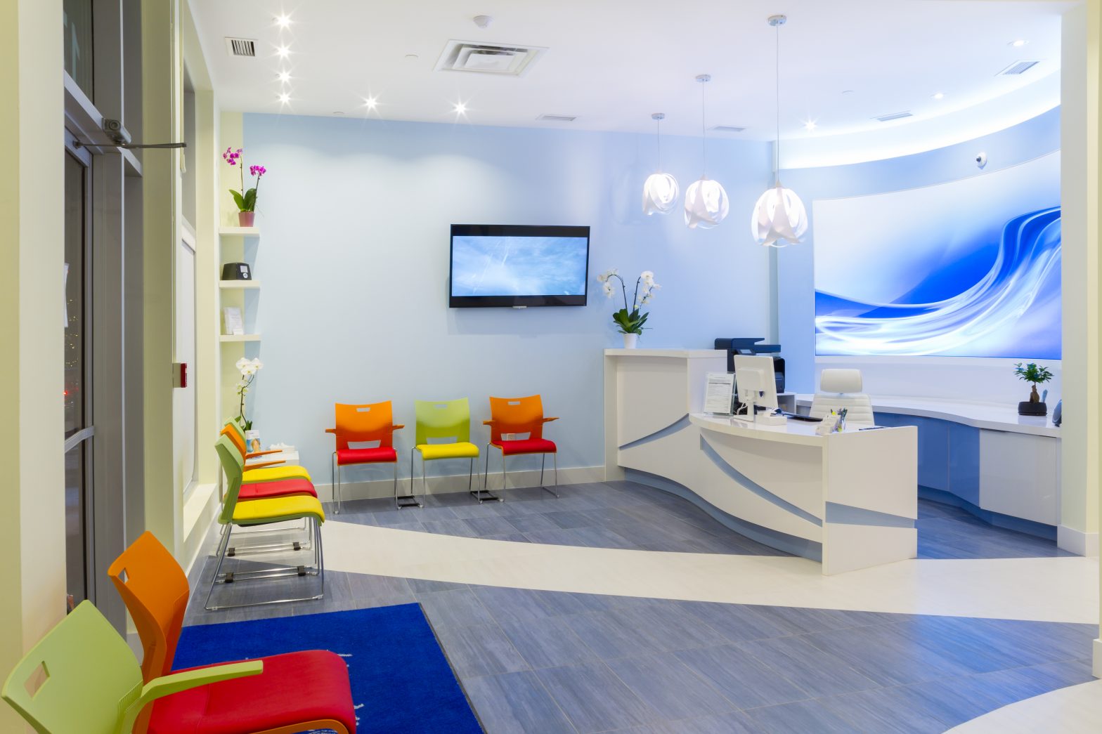 Modern lobby with blue walls and blue floor and digital signage display
