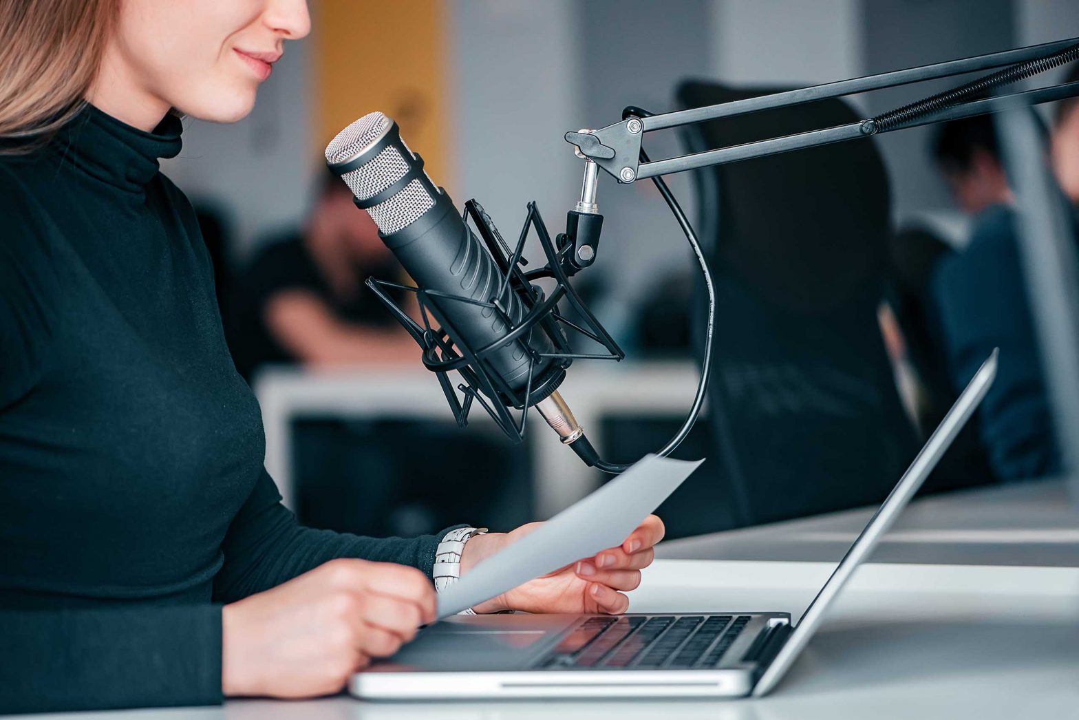 Young woman recording a podcast in a studio, close-up