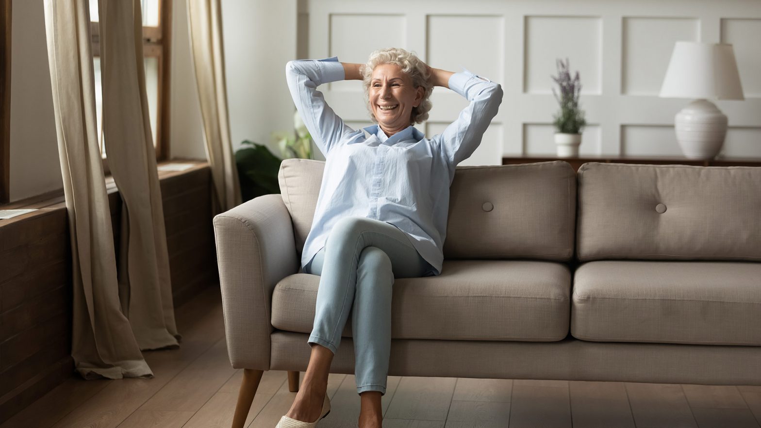 Happy smiling retired senior female relaxing at living room indoor