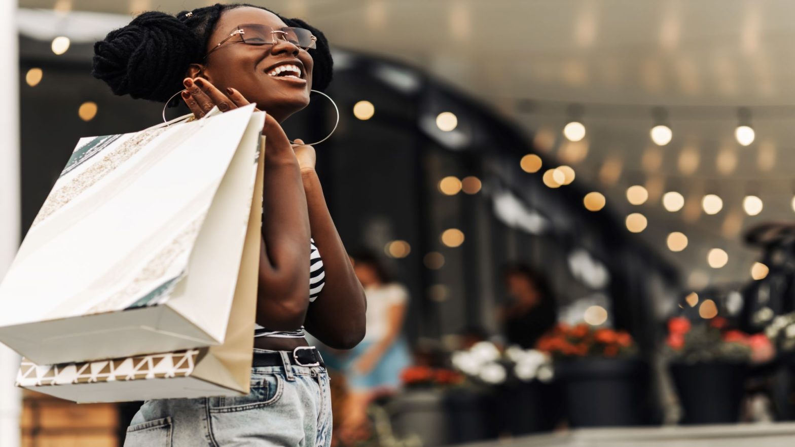 woman smiling while walking with shopping bags