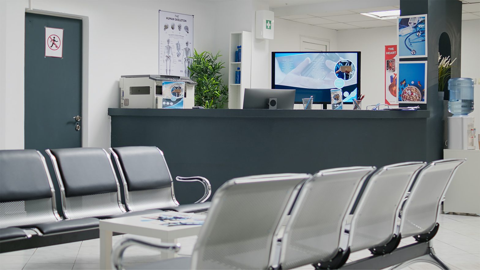 An empty hospital waiting room in a lobby with a reception counter at a medical facility.